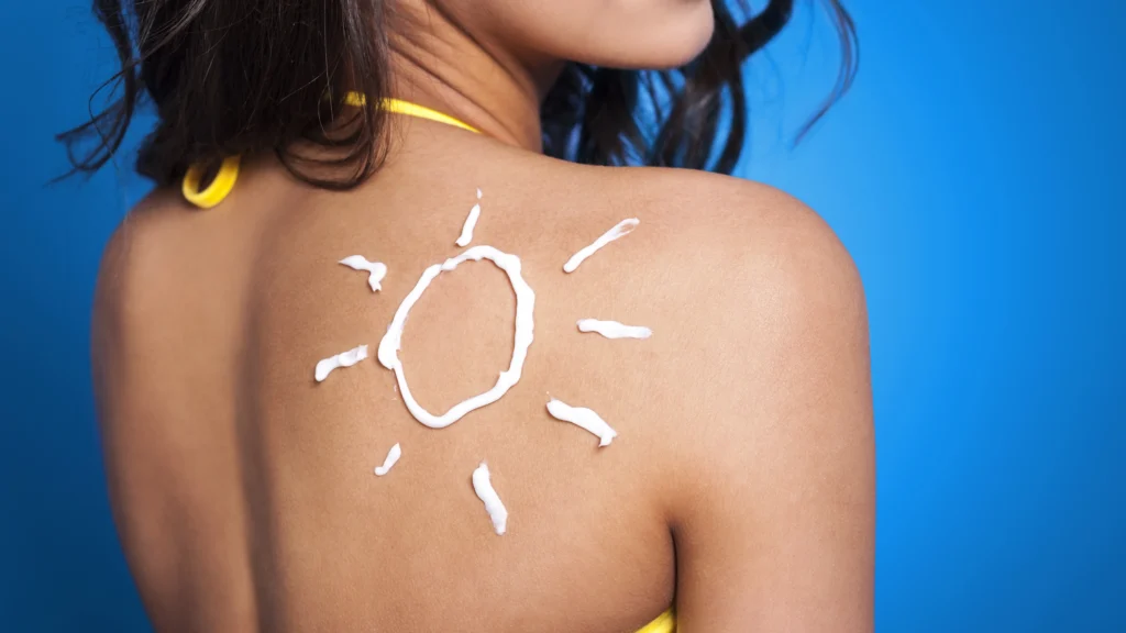 A person with sunscreen applied in the shape of a sun on their back, emphasizing the importance of sun protection as part of a comprehensive skincare routine