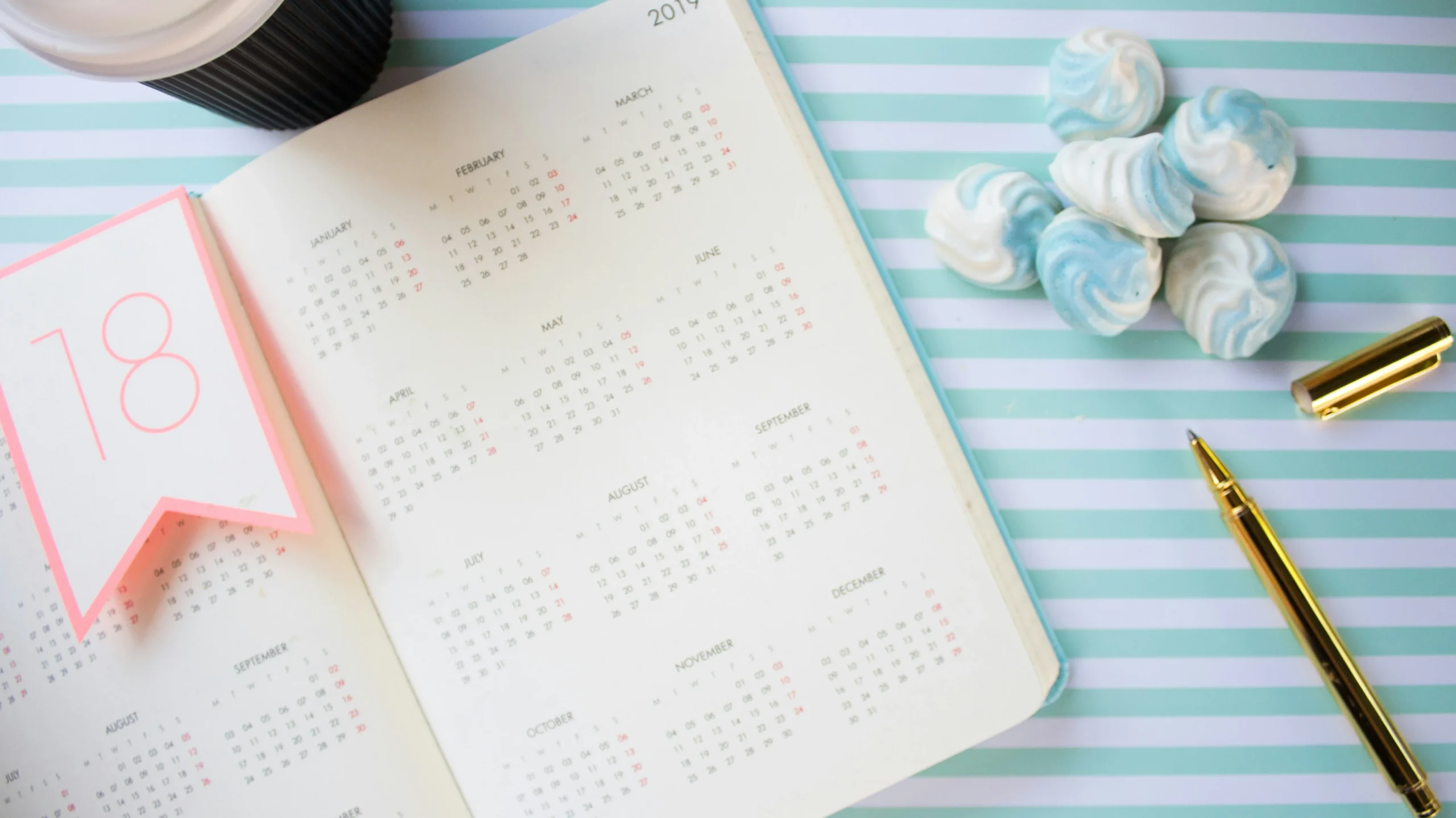 A calendar with a pen and decorative elements, symbolizing the tracking of menstrual cycles and helping to answer questions like 'Why is my period late