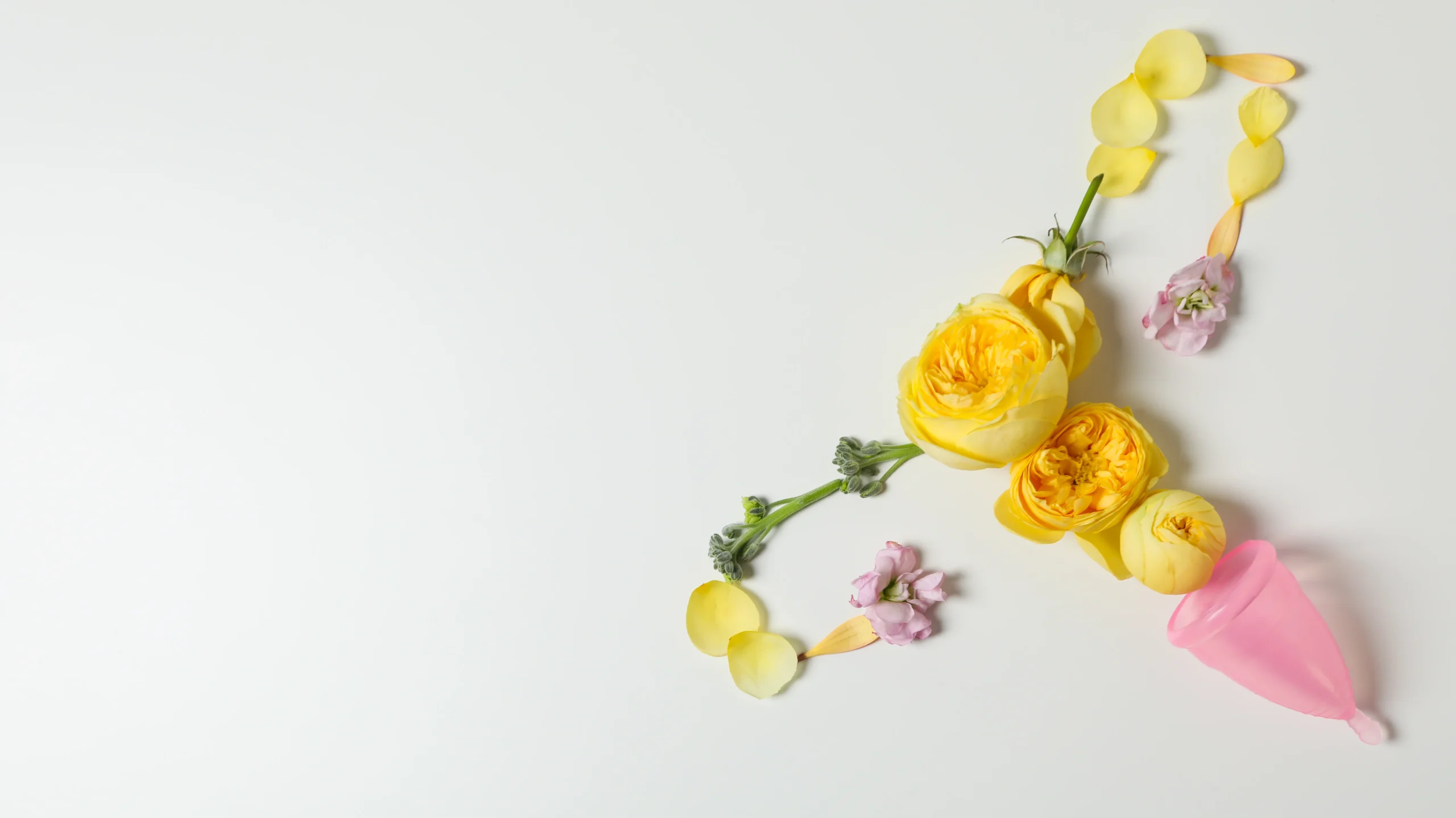 A menstrual cup surrounded by delicate flowers, symbolizing the topic of understanding the Maximum Delay in Periods if Not Pregnant