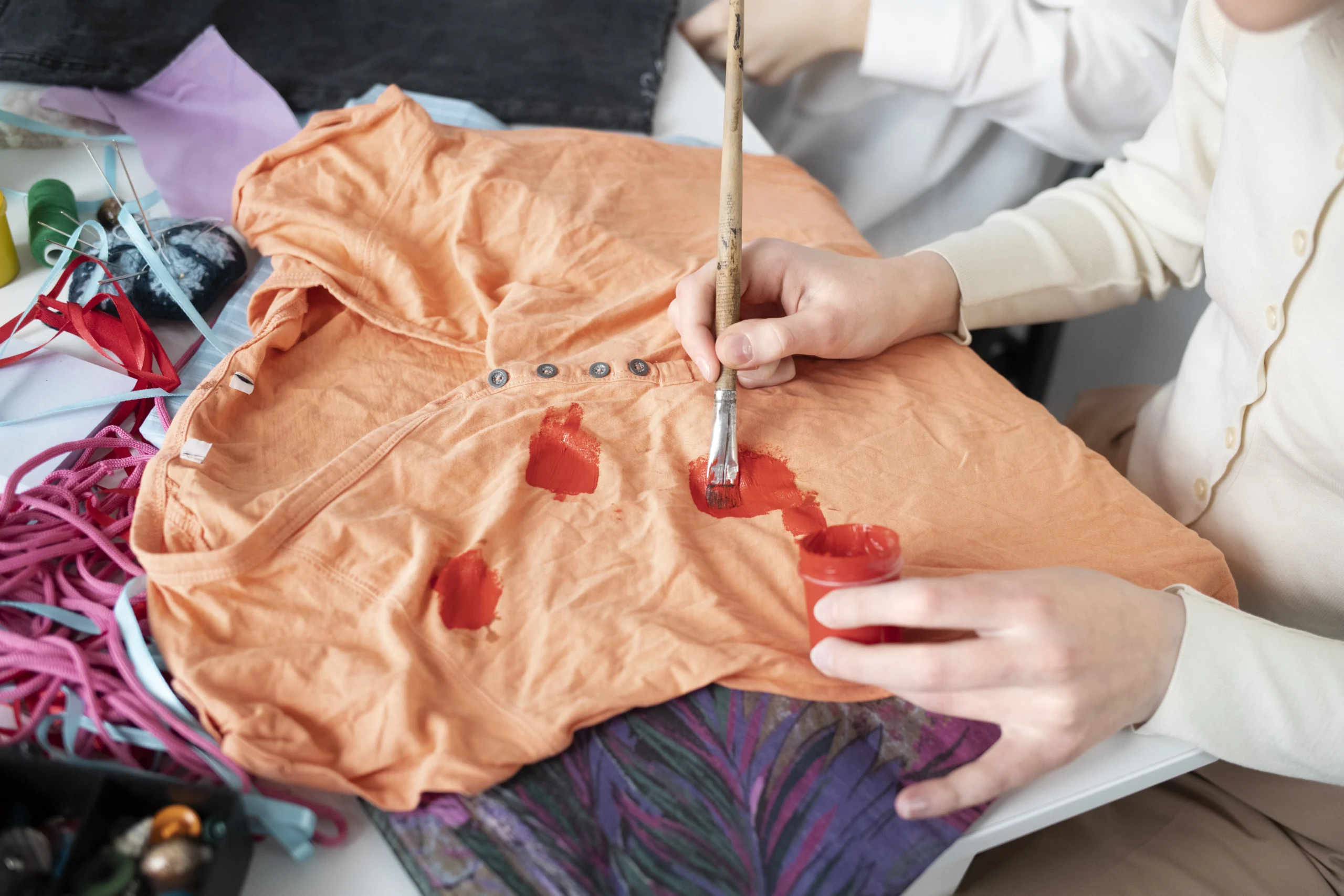 A young adult repurposing fabric scraps into new creations, exploring eco-friendly solutions — including how to get nail polish out of clothes — through creative upcycling and DIY techniques